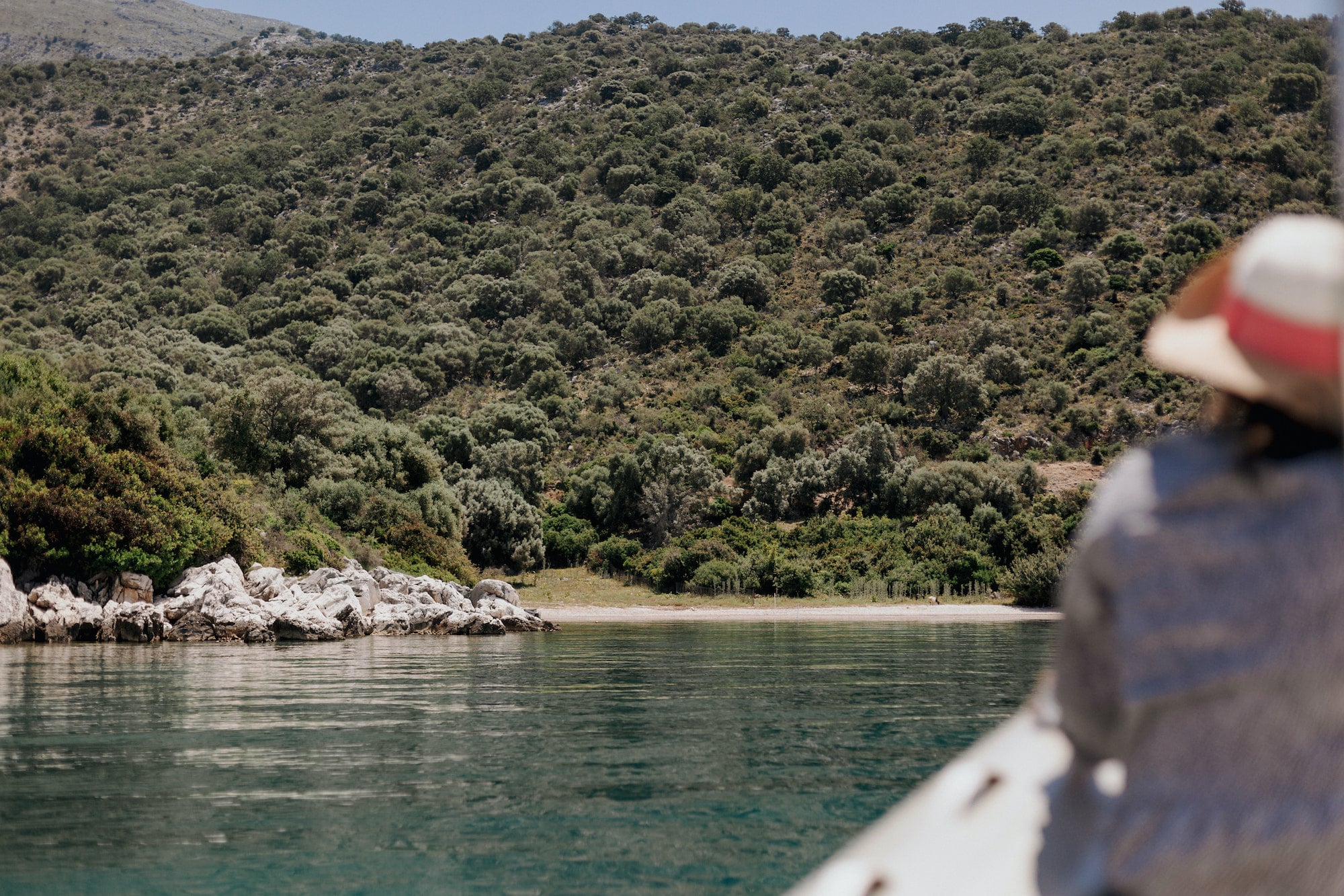 An image of a blurred woman on a boat shortly before arriving at a secluded beach in the Ionian Sea. The photo serves as the cover image for an article about the best day trips from Paleros, written for the blog of Estia Ionian Villas, a luxurious accommodation in Paleros, Greece
