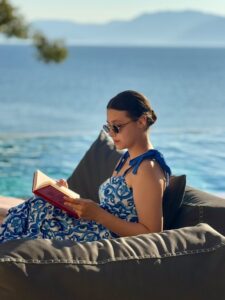 A woman reading a book at her private infinity pool during a summer at Estia Ionian Villas in Paleros