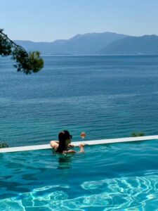 A woman enjoying a drink during summer at Estia Ionian Villas in Paleros